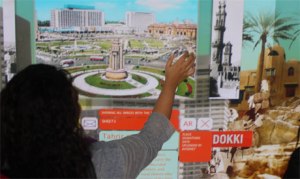 A viewer goes through the images uploaded at the installation 'Sanduq El-Dunia', Copenhagen, Denmark (Photo: Ati Metwaly)