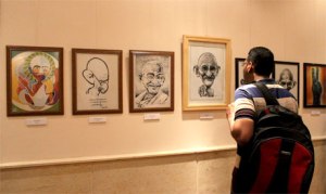 A visitor looks at the row of caricatures, part of "Spirit of Gandhi in Egypt" exhibition that opened in Maulana Azad Centre for Indian Culture on 2 October 2013. (Photo: Ati Metwaly) 